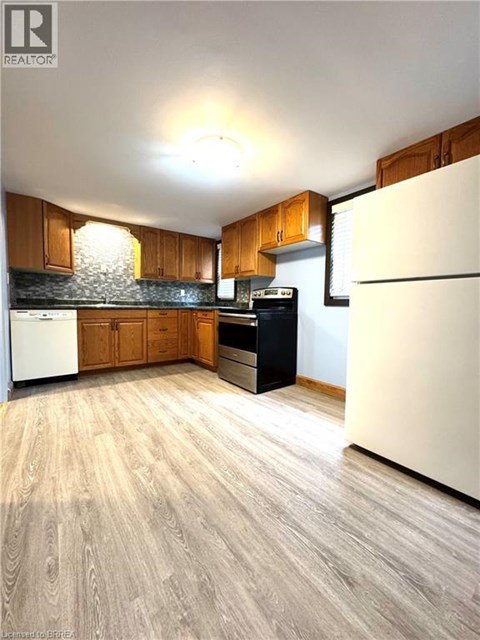 A kitchen with wooden cabinets and a white refrigerator.