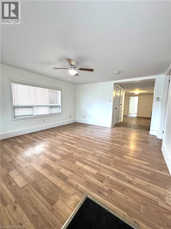 A room with wooden flooring and a ceiling fan.