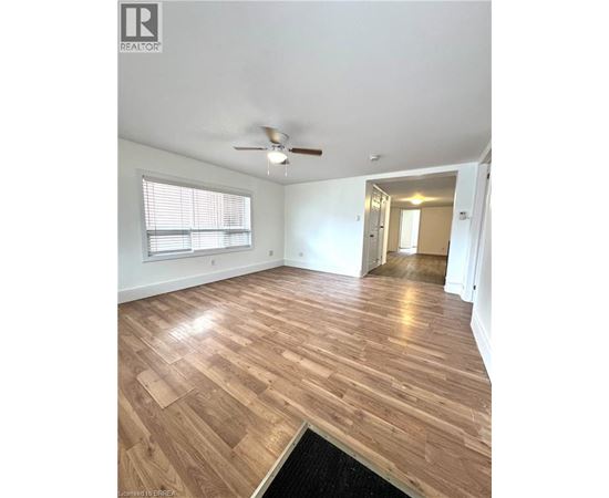 A room with wooden flooring and a ceiling fan.