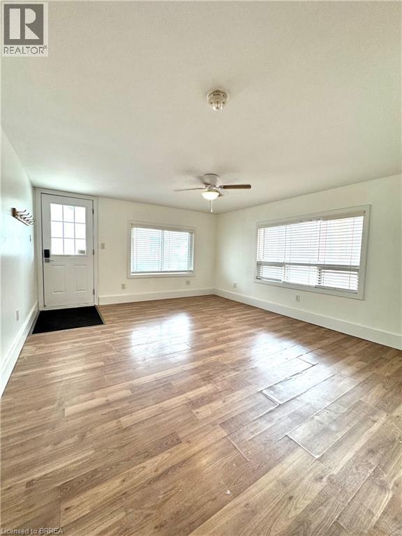 A room with wood flooring and a ceiling fan.