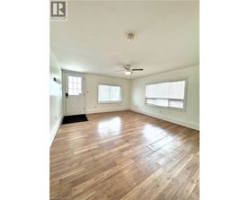 A room with wood flooring and a ceiling fan.