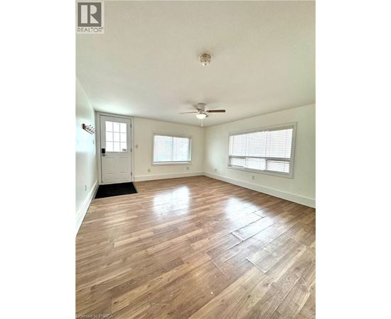 A room with wood flooring and a ceiling fan.
