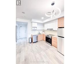 A modern kitchen with white appliances and wooden cabinets.