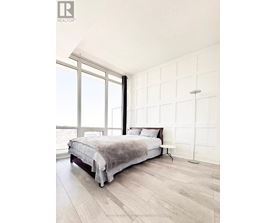 A bedroom with a large bed and a window overlooking the ocean.