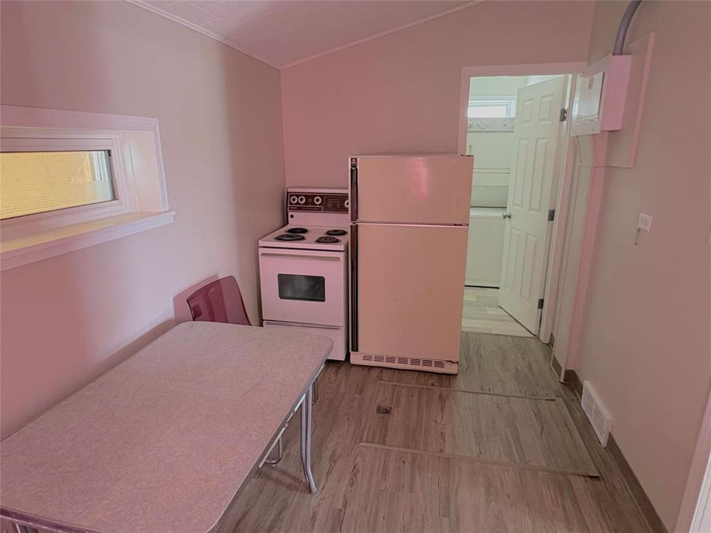 A small kitchen with a refrigerator and a stove.