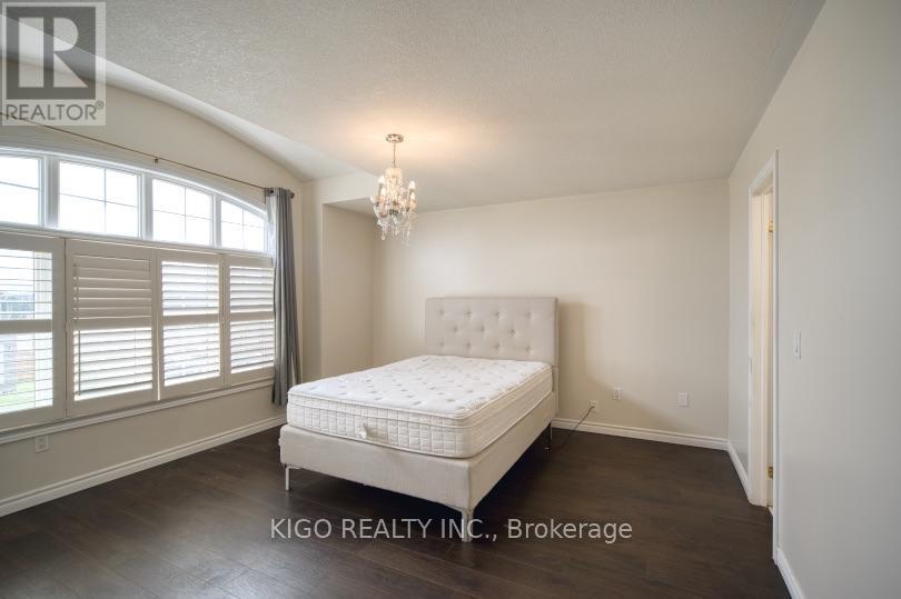 A bedroom with a large bed and a chandelier.