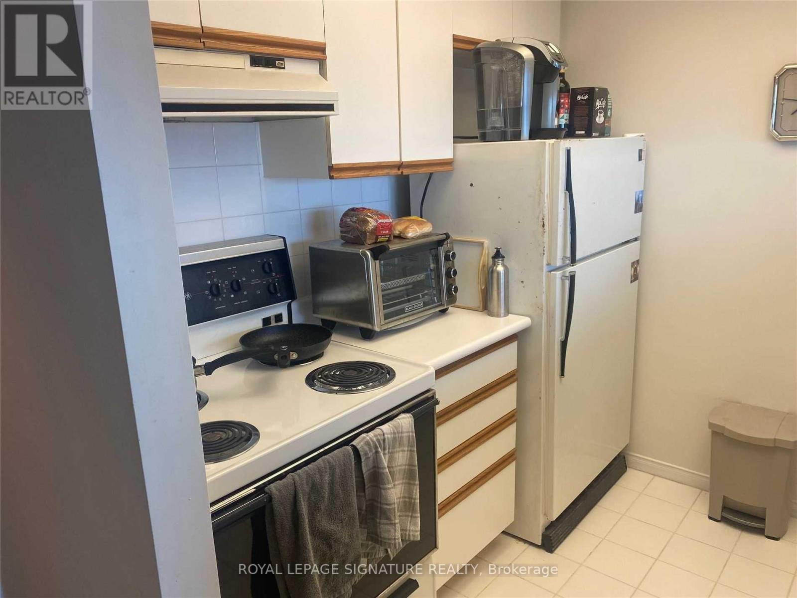A kitchen with a white refrigerator, stove, and oven.