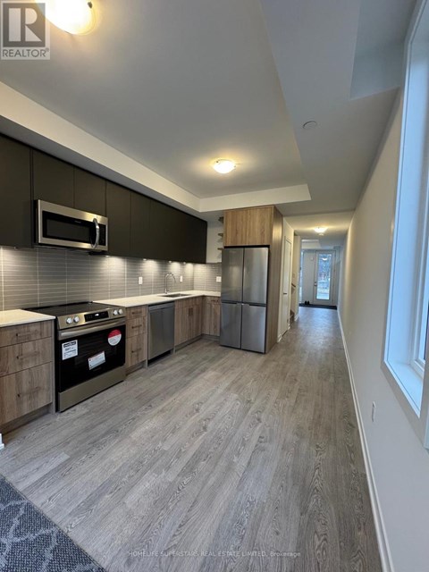 A modern kitchen with dark wood cabinets and a stainless steel refrigerator.