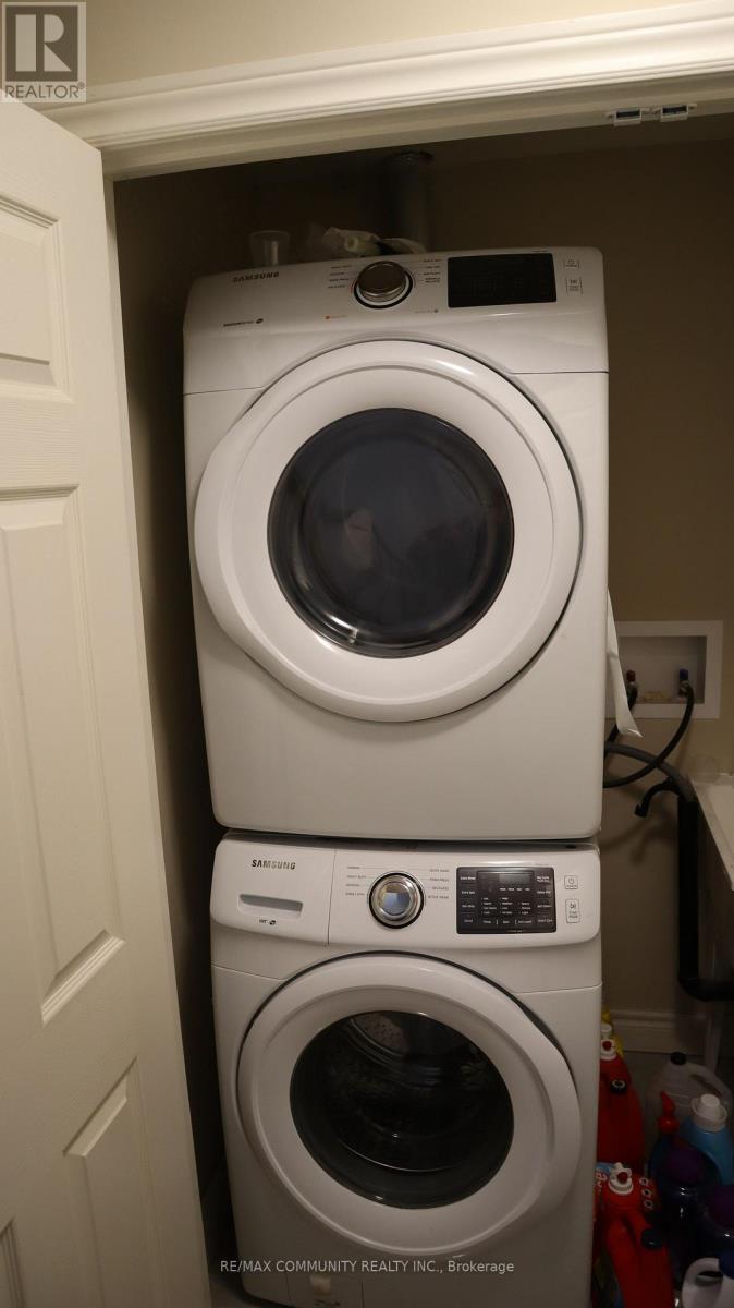 Two white front loading washing machines in a small space.