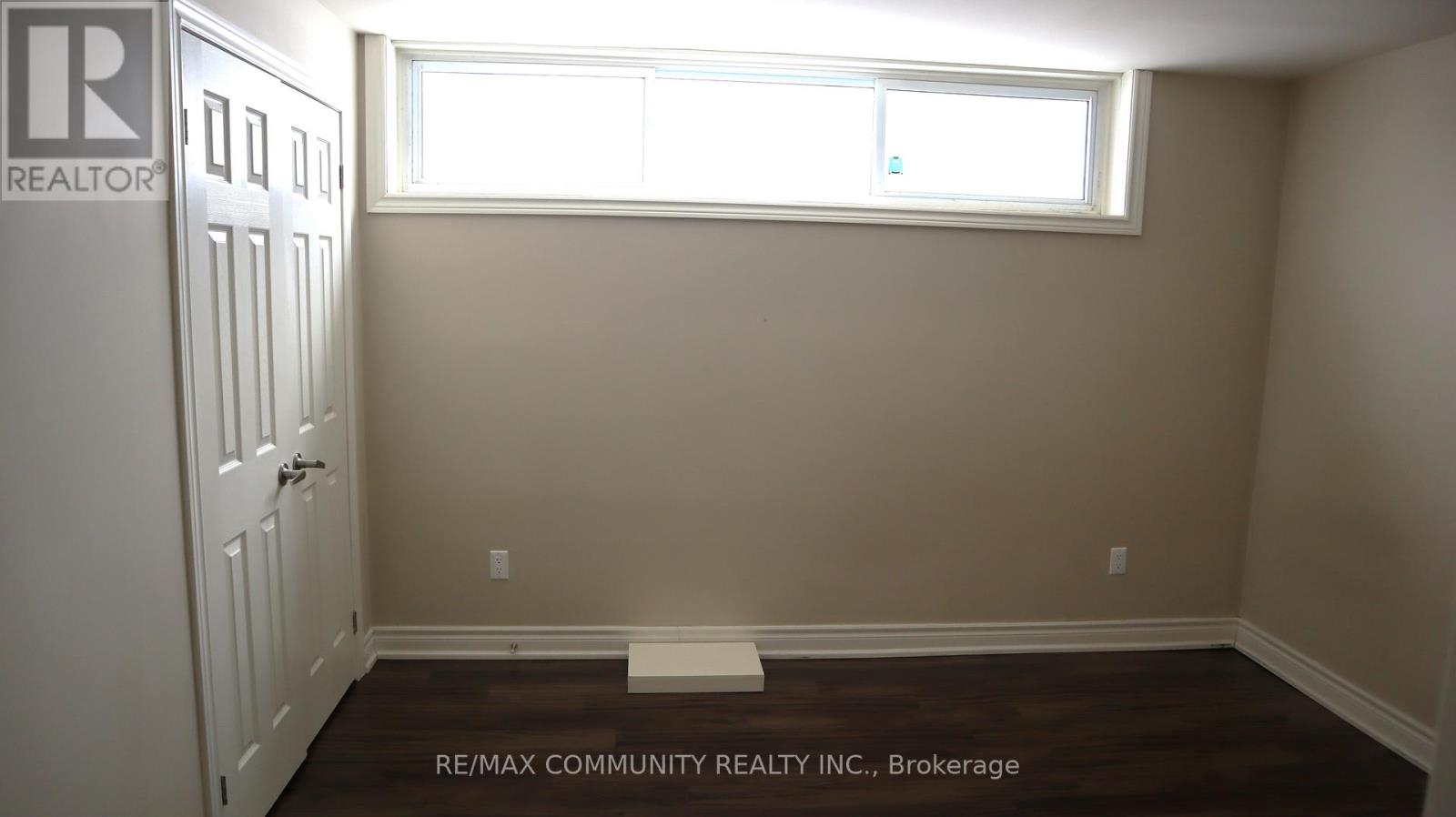 A room with a window and a door, with a sign that says REALTOR.