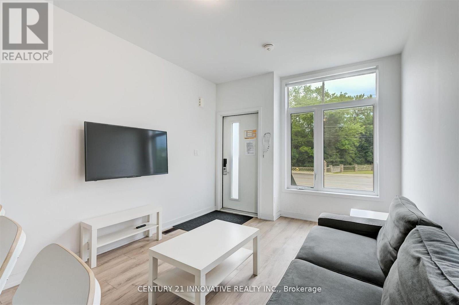 A living room with a flat screen TV mounted on the wall.