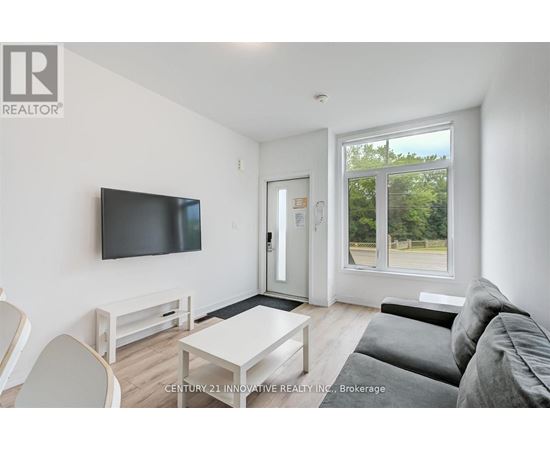 A living room with a flat screen TV mounted on the wall.