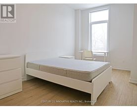 A bedroom with a bed, a chair, and a window.