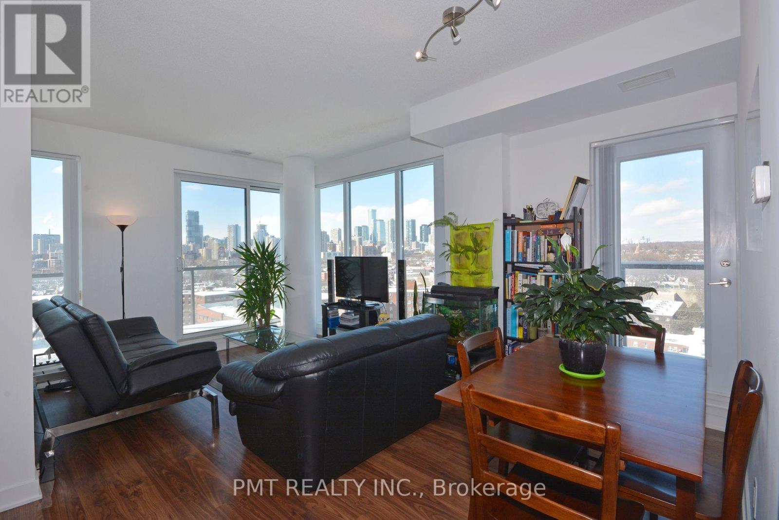 A living room with a couch, chair, and a table with a potted plant on it.