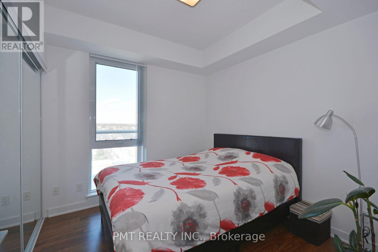 A bedroom with a bed, a window, and a lamp.