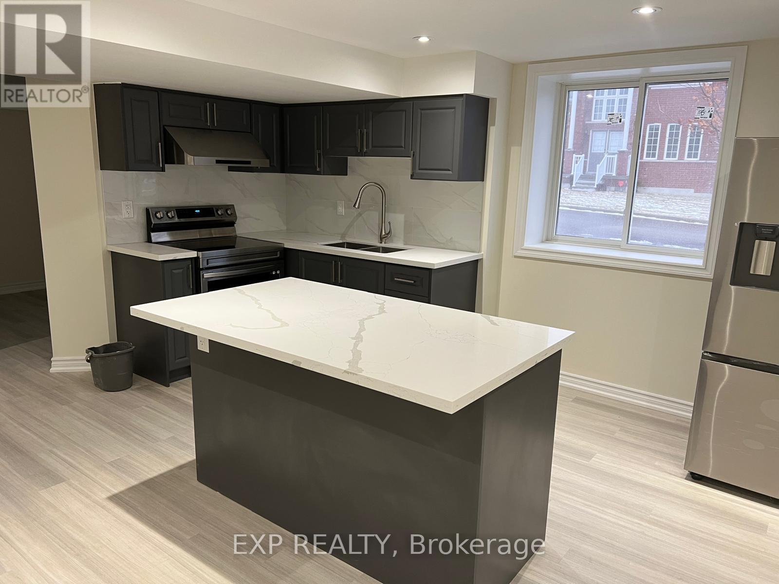 A kitchen with a white counter top and black cabinets.
