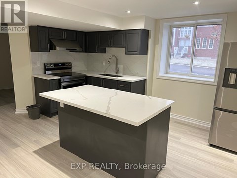 A kitchen with a white counter top and black cabinets.