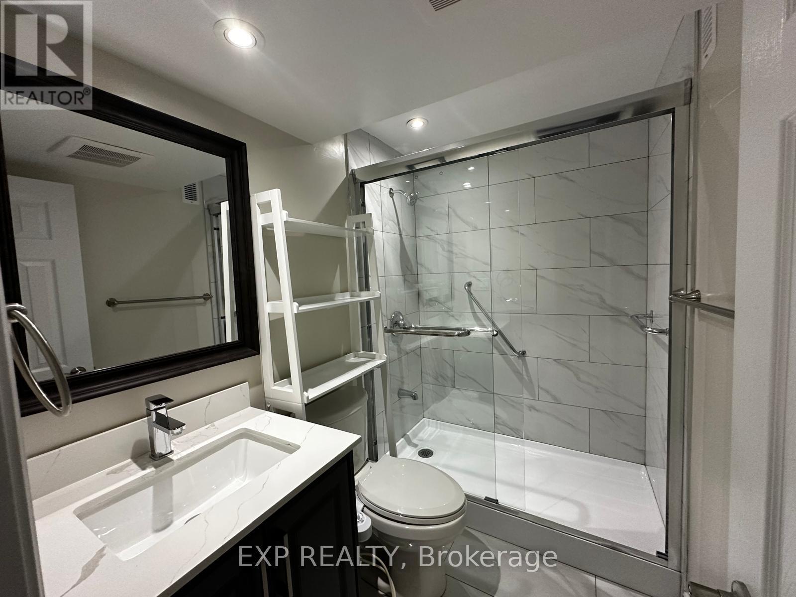 A bathroom with a white toilet and a glass shower stall.