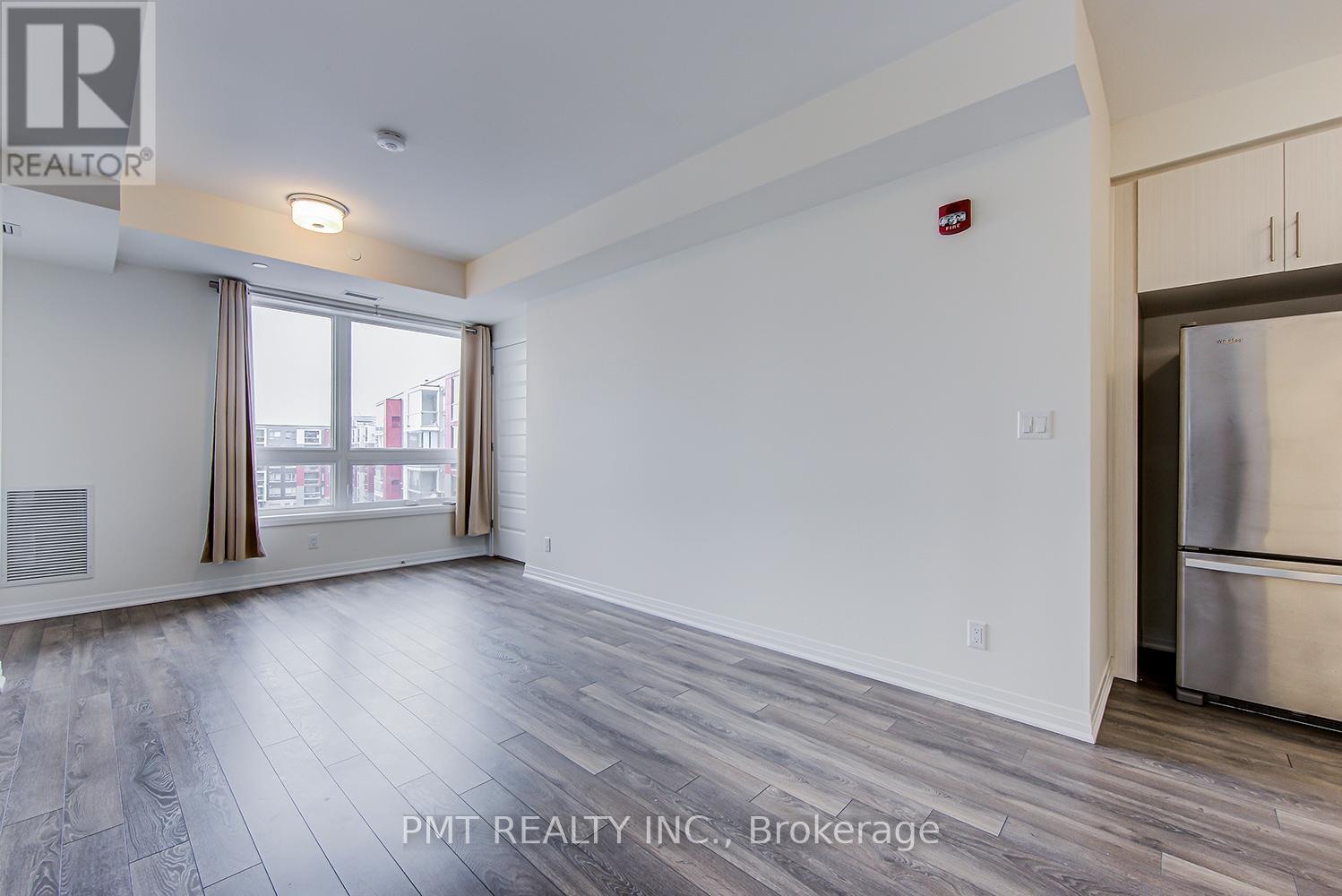 A spacious room with a refrigerator on the right side.