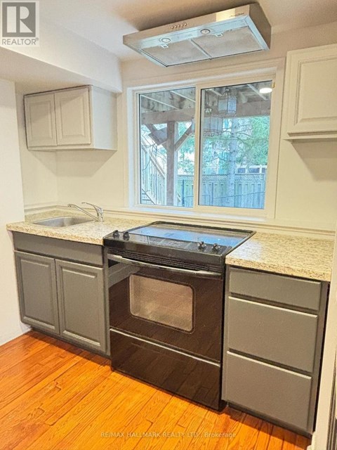A kitchen with a black oven and wooden floors.