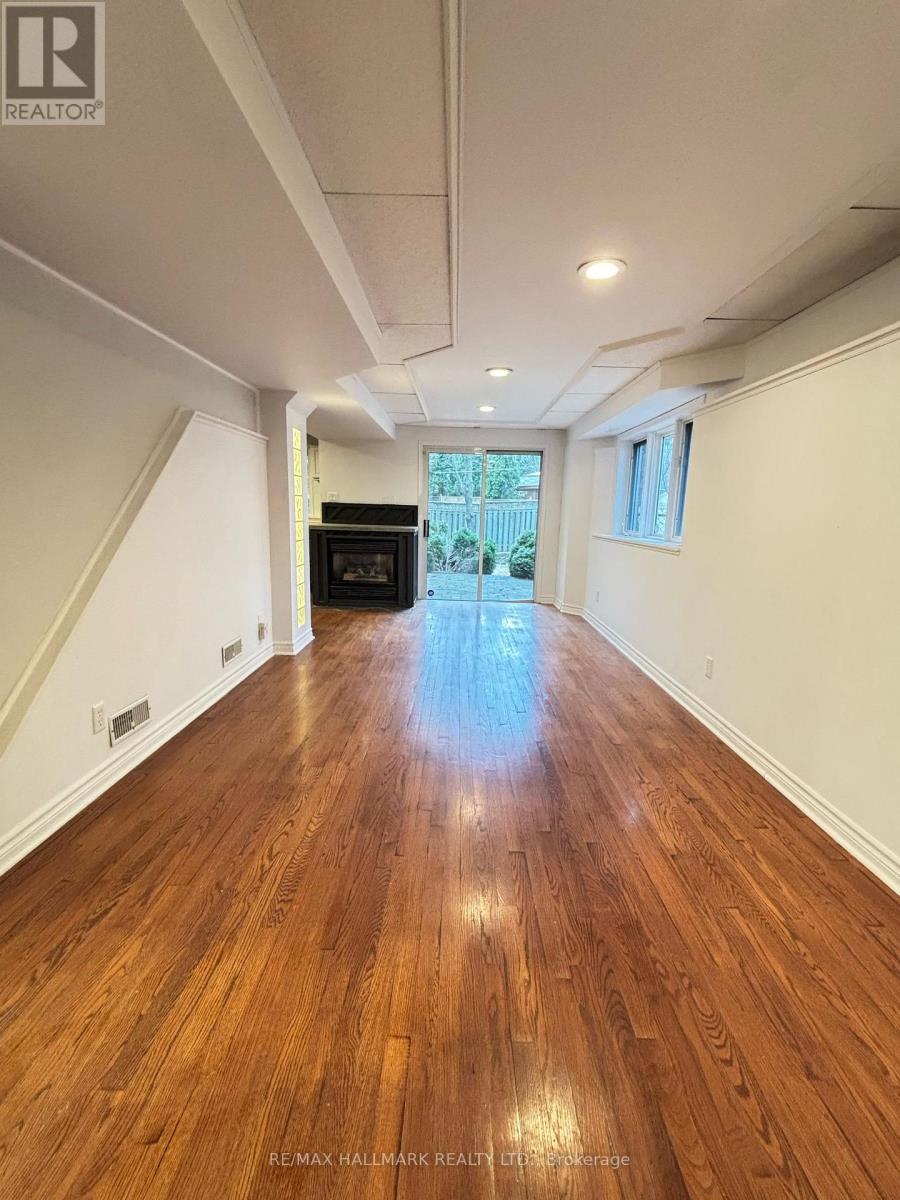 A spacious hallway with wooden floors and white walls.