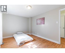 A bedroom with a bed and a painting on the wall.