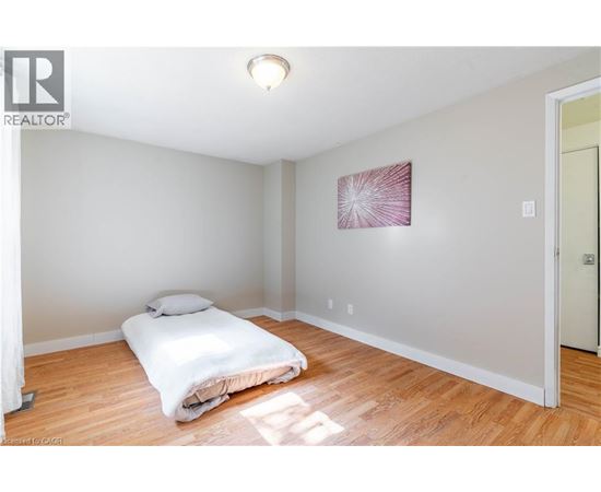 A bedroom with a bed and a painting on the wall.
