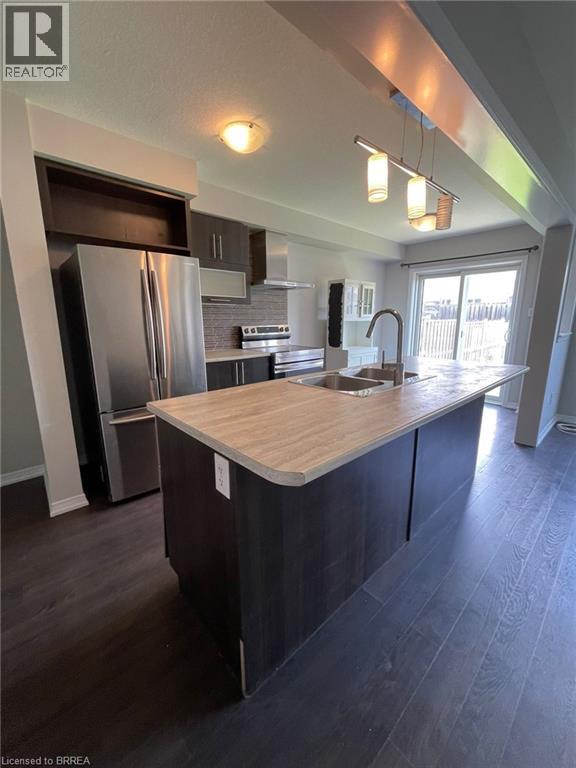 A modern kitchen with a wooden countertop and stainless steel appliances.