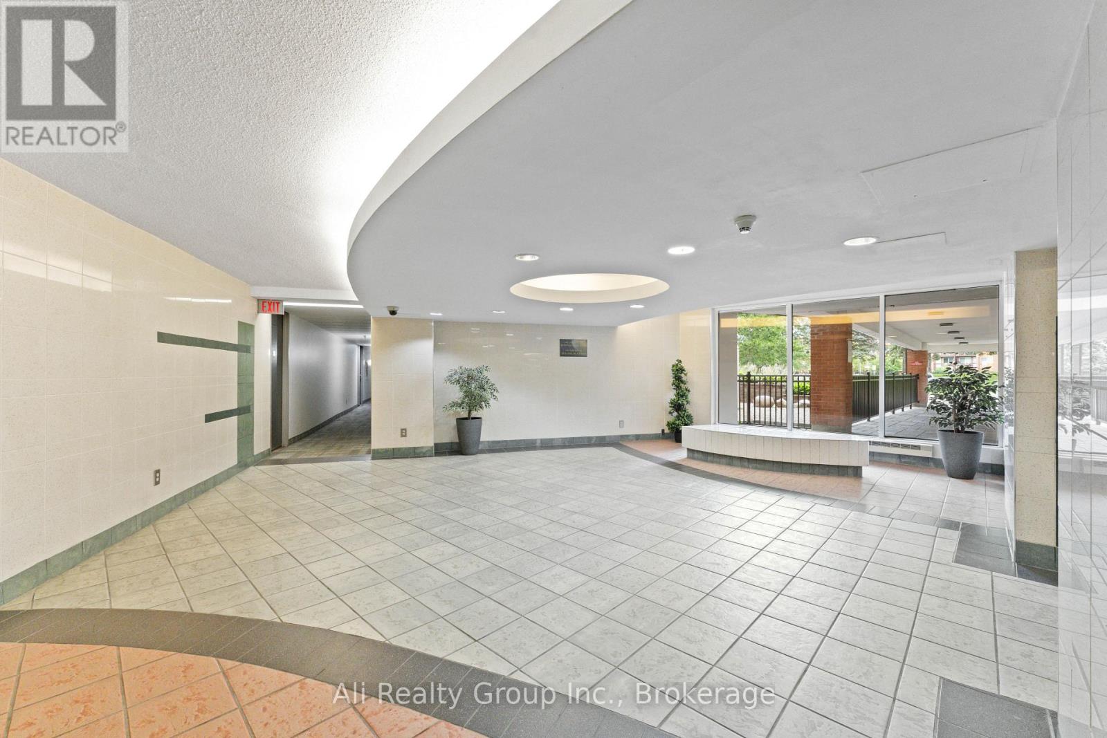 A spacious lobby with a tiled floor and a ceiling with a curved design.