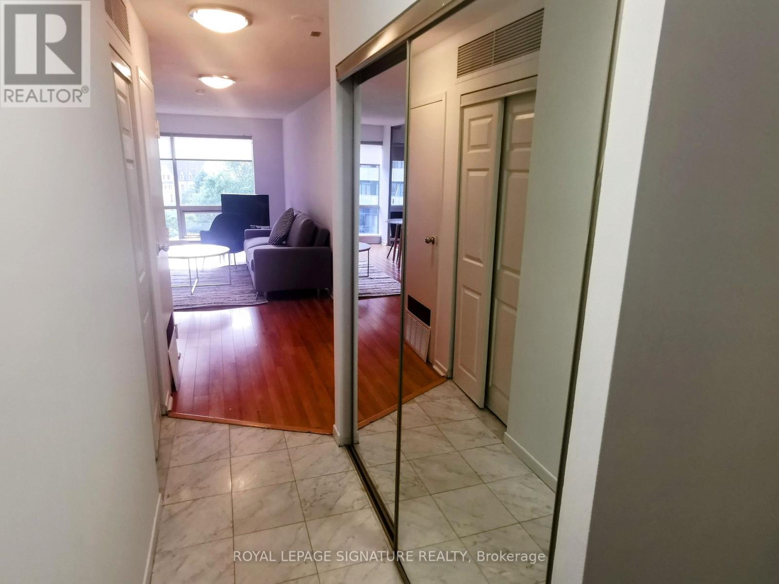 A hallway with a door leading to a living room.