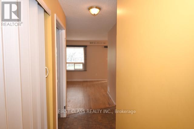 A hallway with a door on the left and a window on the right.