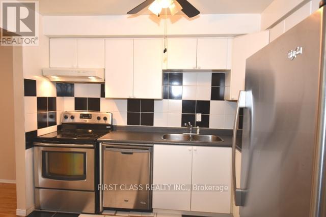 A kitchen with a stove, sink, and refrigerator.