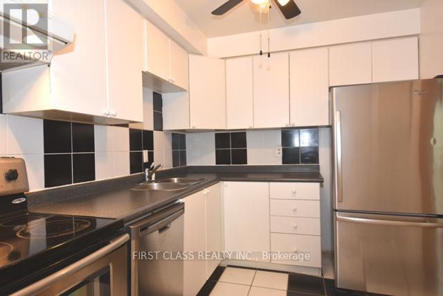A kitchen with white cabinets and black countertops.