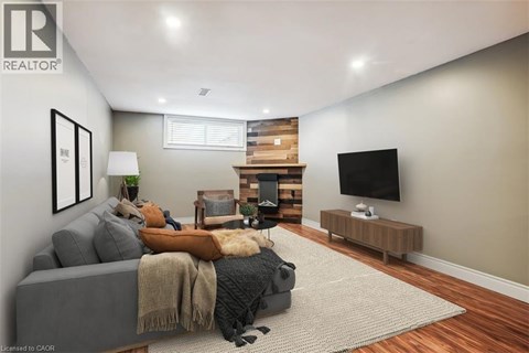 A living room with a grey couch and a wooden fireplace.