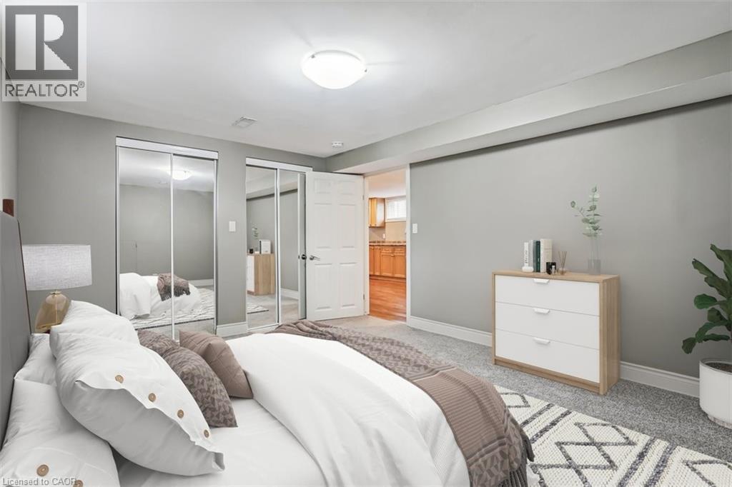 A bedroom with a bed, nightstand, and a plant.