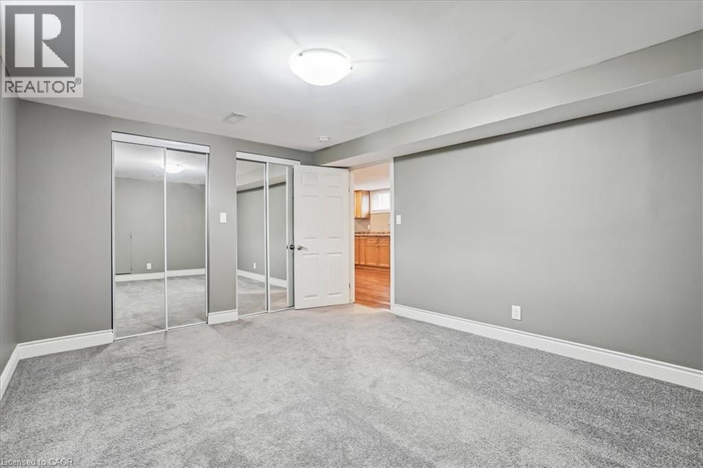 A spacious room with grey carpeting and a sliding glass door.
