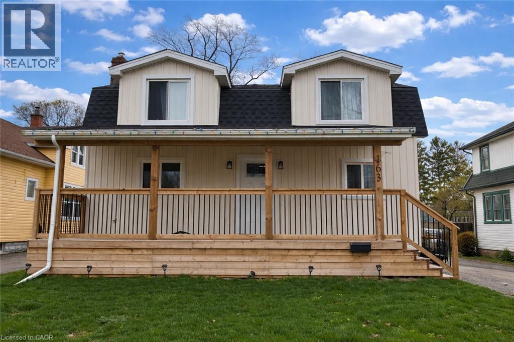 A two-story house with a wooden deck in front.