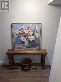 A painting of flowers in a vase sits on a wooden bench.