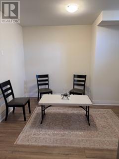 A white table with a pair of chairs sits in a room.