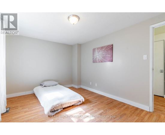 A bedroom with a bed and a painting on the wall.