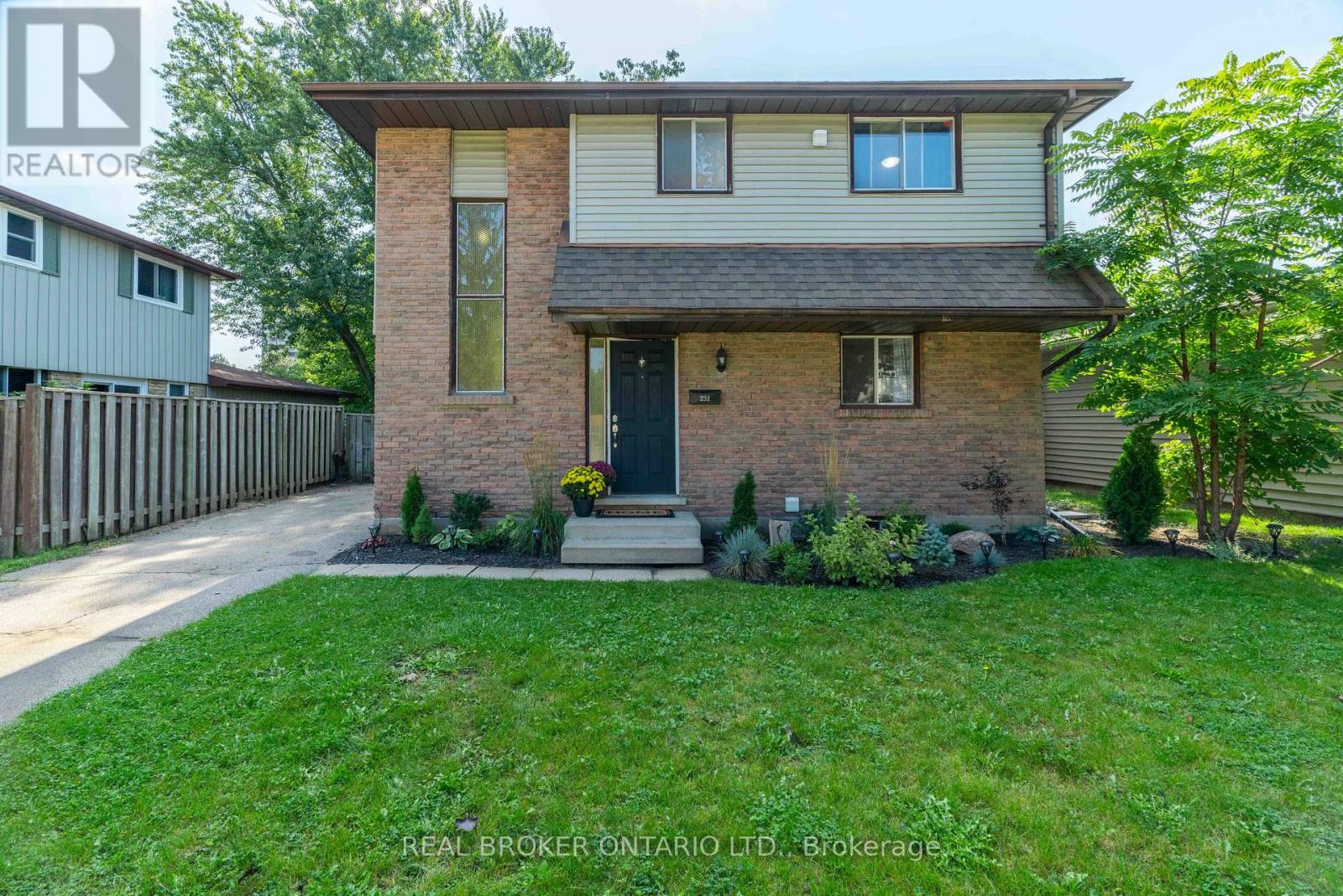 A house with a brown brick facade and a grey roof is for sale.