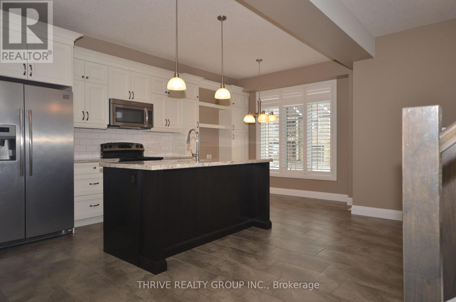 A kitchen with a black island in the middle.