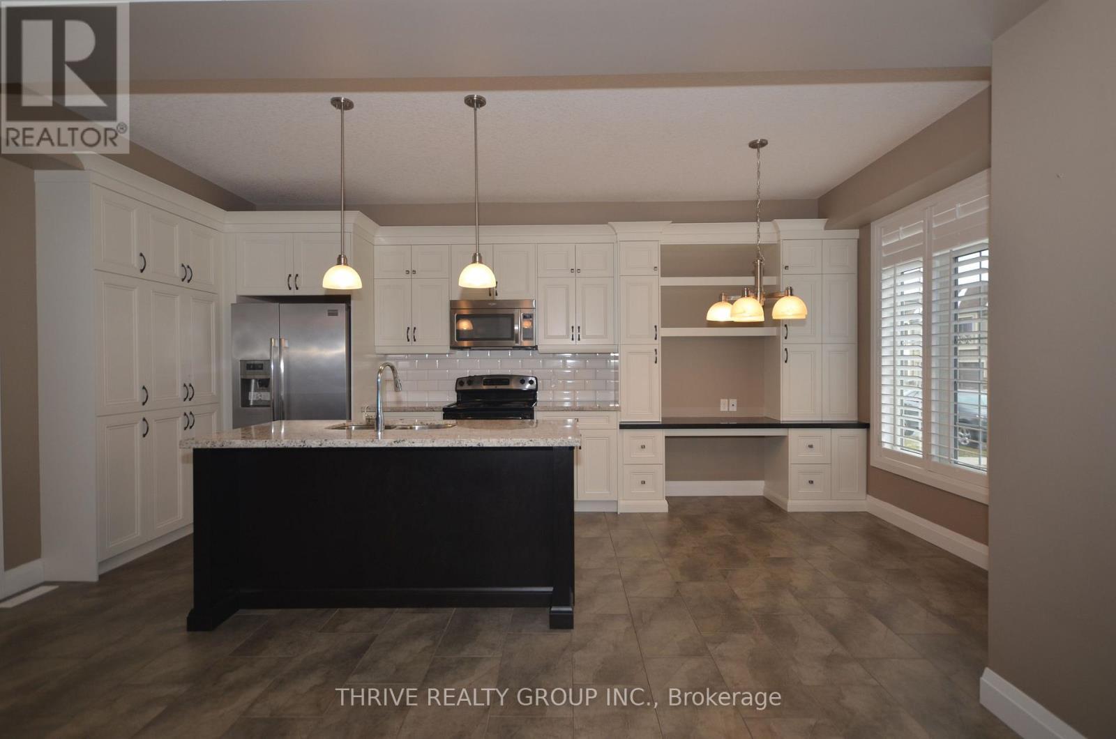 A kitchen with a black island in the middle.