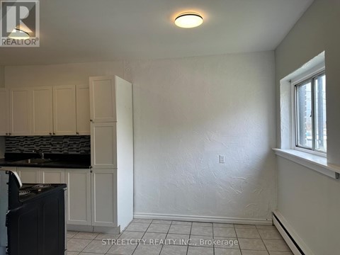 A kitchen with white cabinets and black countertops.