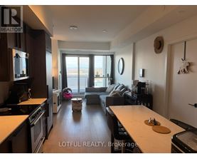 A modern kitchen with a dining area in the background.