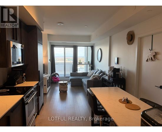 A modern kitchen with a dining area in the background.