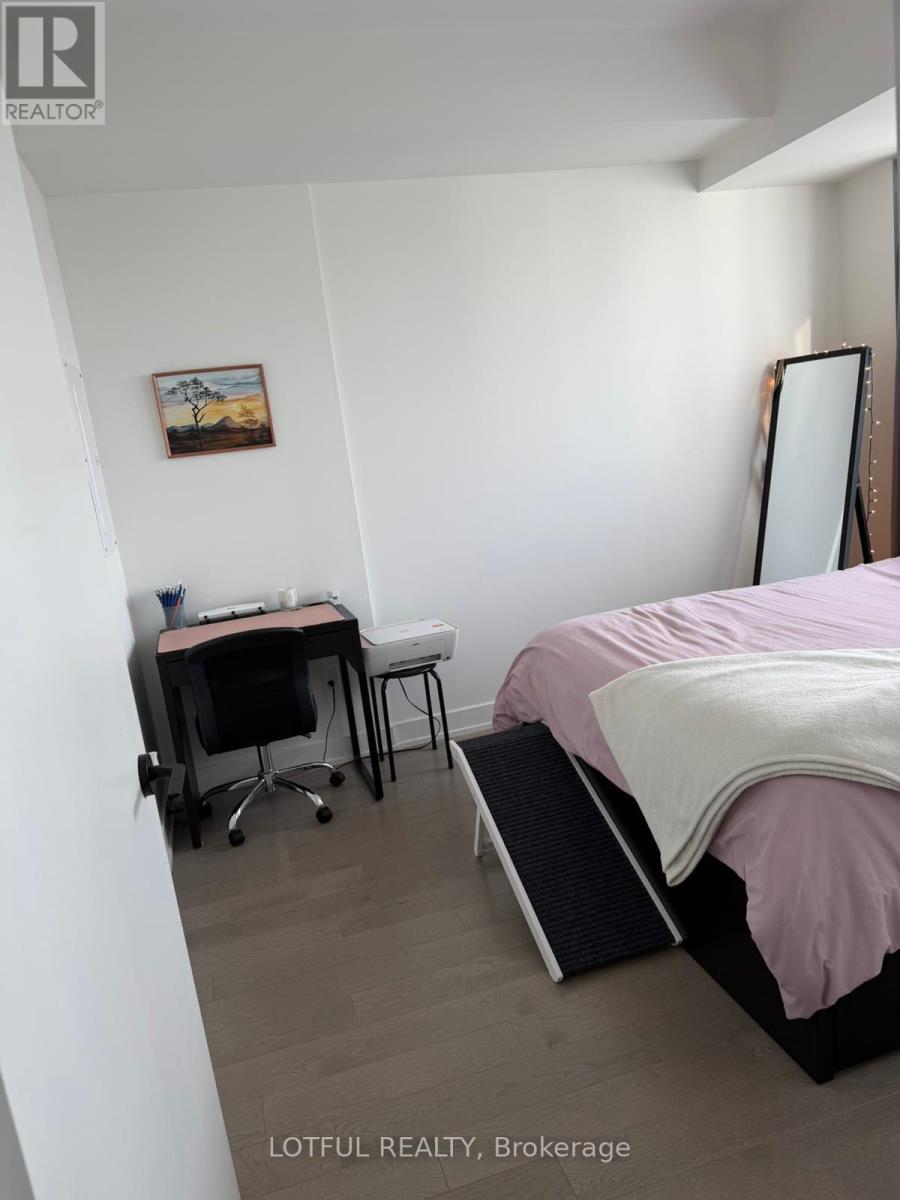 A bedroom with a bed, desk, and chair.