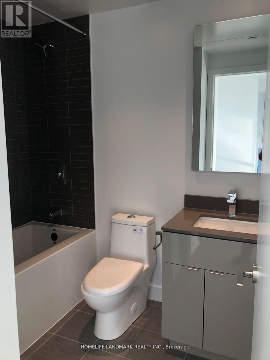 A white toilet in a bathroom with a sink and mirror.