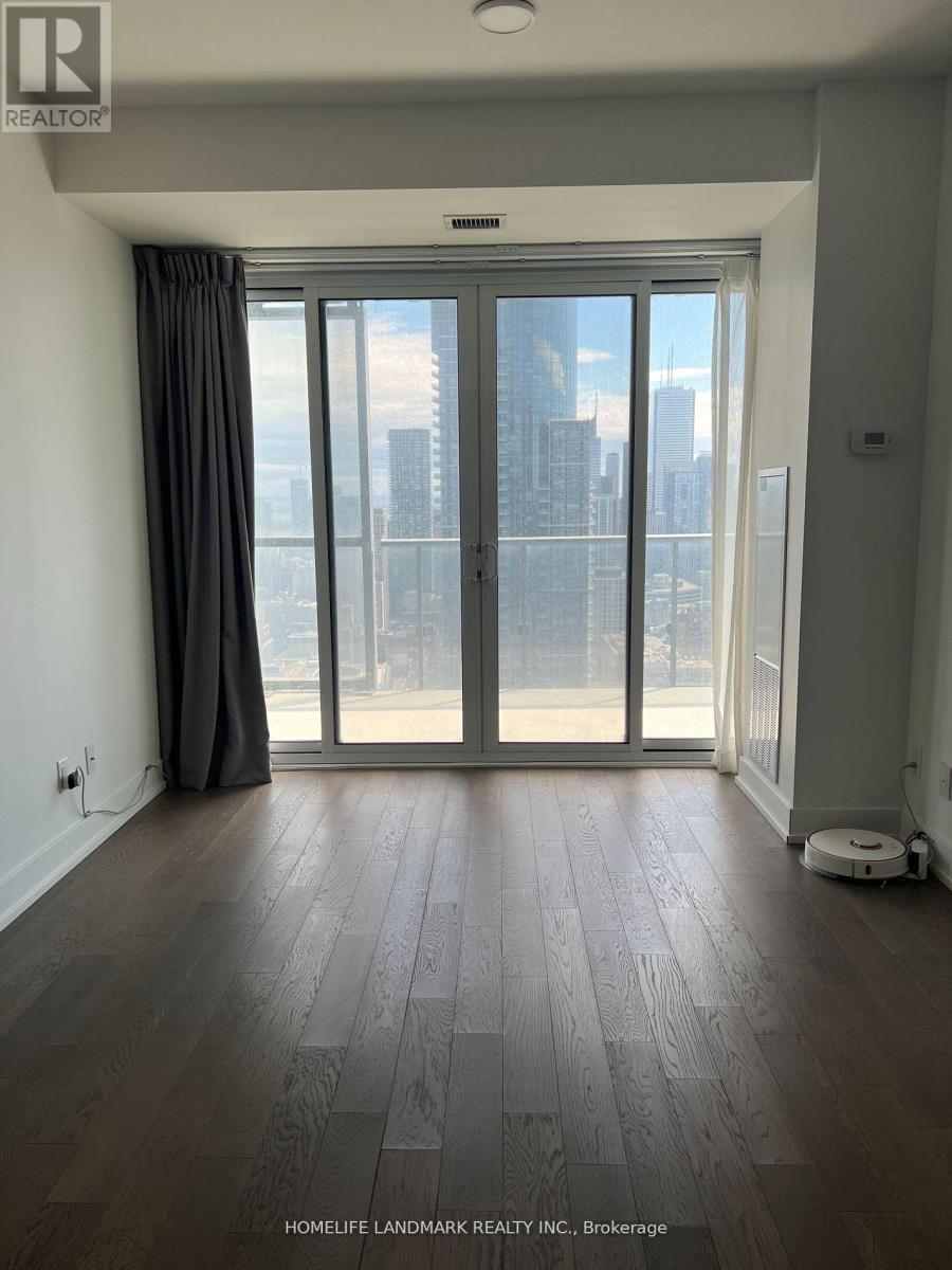 A room with a large window and wooden flooring.
