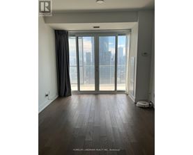 A room with a large window and wooden flooring.